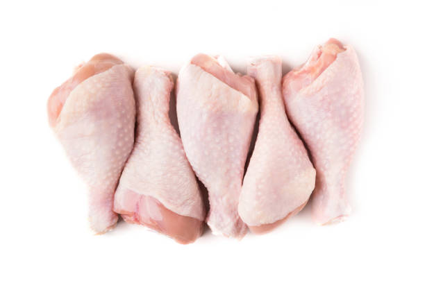 Uncooked chicken legs in row isolated on white background, top view